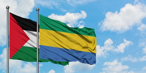 Palestine and Gabon flag waving in the wind against white cloudy blue sky together. Diplomacy concept, international relations.