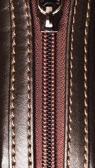 zipper of brown leather bag, close-up view