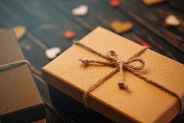 Two brown gift boxes on a wooden background with a bow of a simple rope on wood backgraund.