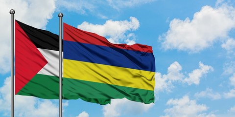 Palestine and Mauritius flag waving in the wind against white cloudy blue sky together. Diplomacy concept, international relations.