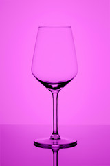 Empty wine goblet on purple abstract vignette background