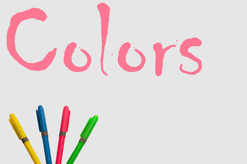 Colored markers on a white background, accompanied by the word color and with a fun design