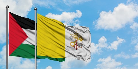 Palestine and Vatican City flag waving in the wind against white cloudy blue sky together....