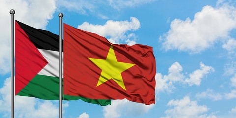 Palestine and Vietnam flag waving in the wind against white cloudy blue sky together. Diplomacy concept, international relations.