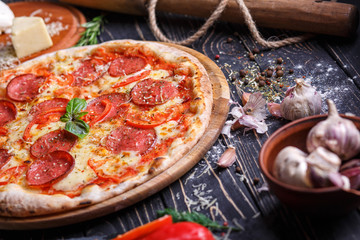 Pizza with sausage and tomatoes near spices