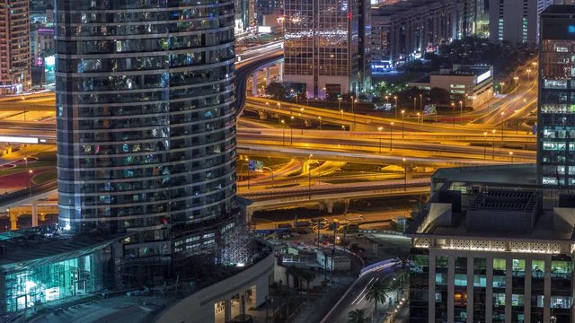 Aerial view of highway interchange in Dubai downtown night timelapse. Cityscapes traffic bridge and parking. Roads and lanes Crossroads, Dubai, United Arab Emirates