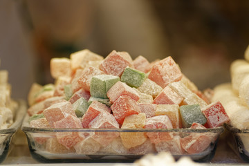 Turkish Delight of different colors and powdered surface in a glass container. Coconut also used for powdering. Locally known as Turkish Lokum.
