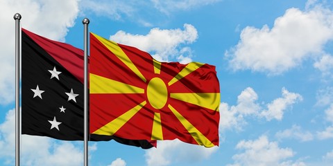 Papua New Guinea and Macedonia flag waving in the wind against white cloudy blue sky together. Diplomacy concept, international relations.
