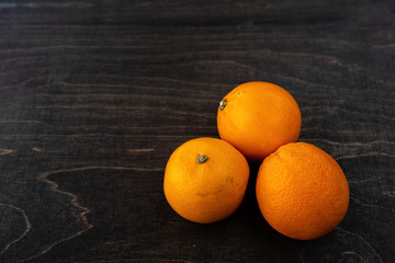 A closeup photo of vibrant organic blood oranges on a dark background with copy space.