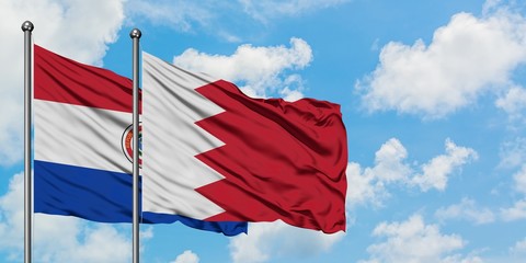 Paraguay and Bahrain flag waving in the wind against white cloudy blue sky together. Diplomacy concept, international relations.