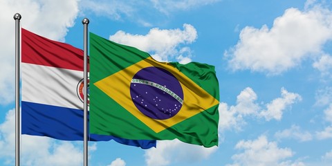 Paraguay and Brazil flag waving in the wind against white cloudy blue sky together. Diplomacy concept, international relations.