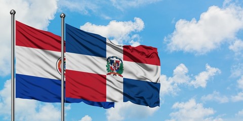 Paraguay and Dominican Republic flag waving in the wind against white cloudy blue sky together. Diplomacy concept, international relations.