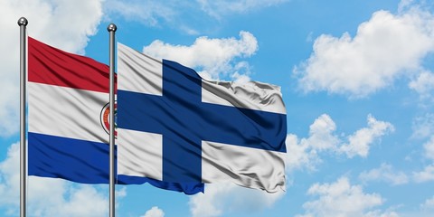 Paraguay and Finland flag waving in the wind against white cloudy blue sky together. Diplomacy...