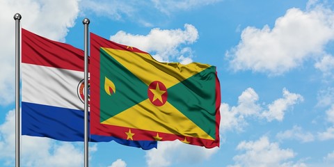 Paraguay and Grenada flag waving in the wind against white cloudy blue sky together. Diplomacy concept, international relations.