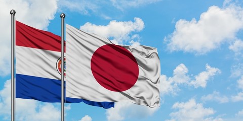 Paraguay and Japan flag waving in the wind against white cloudy blue sky together. Diplomacy concept, international relations.