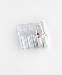 Two ampoules in a package on a white background. Incomplete course of treatment. Copy space.