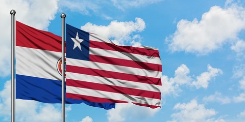 Paraguay and Liberia flag waving in the wind against white cloudy blue sky together. Diplomacy concept, international relations.
