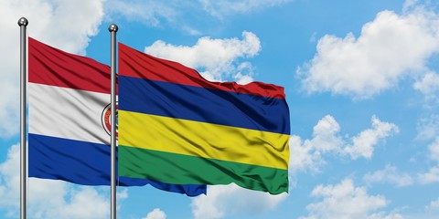 Paraguay and Mauritius flag waving in the wind against white cloudy blue sky together. Diplomacy concept, international relations.