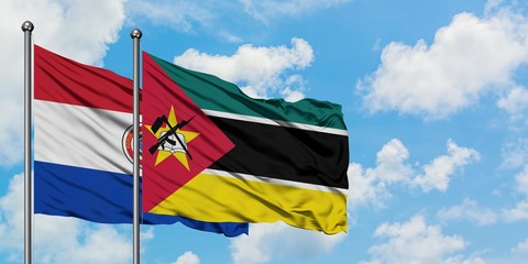 Paraguay and Mozambique flag waving in the wind against white cloudy blue sky together. Diplomacy concept, international relations.