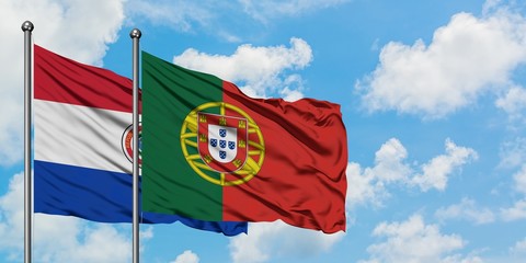 Paraguay and Portugal flag waving in the wind against white cloudy blue sky together. Diplomacy concept, international relations.