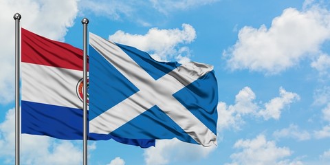 Paraguay and Scotland flag waving in the wind against white cloudy blue sky together. Diplomacy concept, international relations.