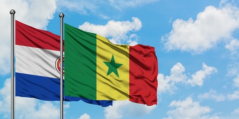 Paraguay and Senegal flag waving in the wind against white cloudy blue sky together. Diplomacy concept, international relations.