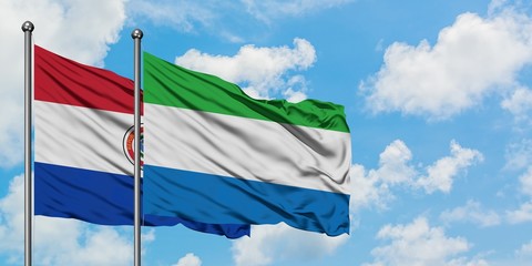 Paraguay and Sierra Leone flag waving in the wind against white cloudy blue sky together. Diplomacy concept, international relations.