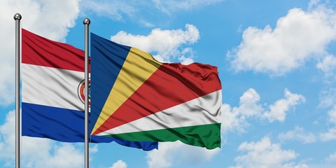 Paraguay and Seychelles flag waving in the wind against white cloudy blue sky together. Diplomacy concept, international relations.