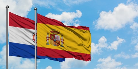 Paraguay and Spain flag waving in the wind against white cloudy blue sky together. Diplomacy concept, international relations.