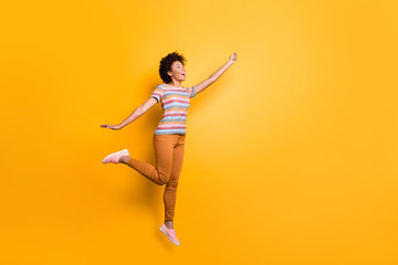 Side profile full length body size photo of cheerful excited positive nice pretty girlfriend having caught umbrella in orange pants striped t-shirt footwear isolated vibrant color background