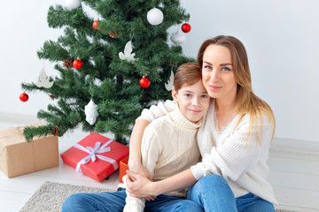 Single parent and holidays concept - Portrait of mother and child celebrating christmas at home on...