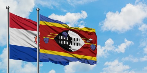 Paraguay and Swaziland flag waving in the wind against white cloudy blue sky together. Diplomacy concept, international relations.