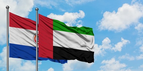 Paraguay and United Arab Emirates flag waving in the wind against white cloudy blue sky together. Diplomacy concept, international relations.