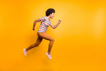 Fototapeta na wymiar Full size profile photo of jumping high dark skin wavy lady speed race running competition participant wear casual clothes isolated bright yellow color background