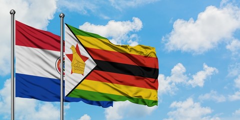 Paraguay and Zimbabwe flag waving in the wind against white cloudy blue sky together. Diplomacy concept, international relations.