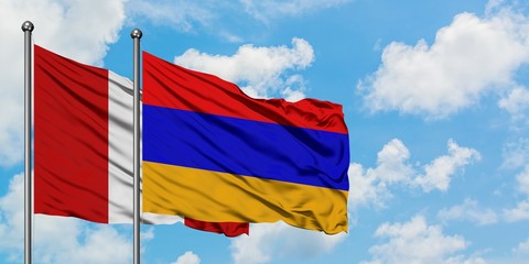 Peru and Armenia flag waving in the wind against white cloudy blue sky together. Diplomacy concept, international relations.