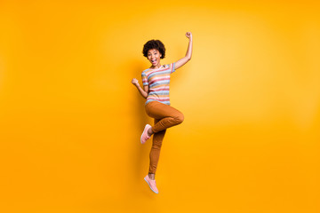 Yeah discounts. Full length photo of crazy funky brunette wavy hair girl jump raise fists scream win spring bargain lottery wear casual style outfit isolated over bright color background
