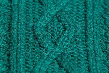 Green knitted texture of cozy warm winter clothes. Top view flatlay color photogaphy.
