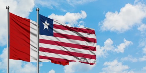 Peru and Liberia flag waving in the wind against white cloudy blue sky together. Diplomacy concept, international relations.