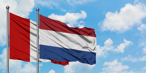 Peru and Netherlands flag waving in the wind against white cloudy blue sky together. Diplomacy concept, international relations.