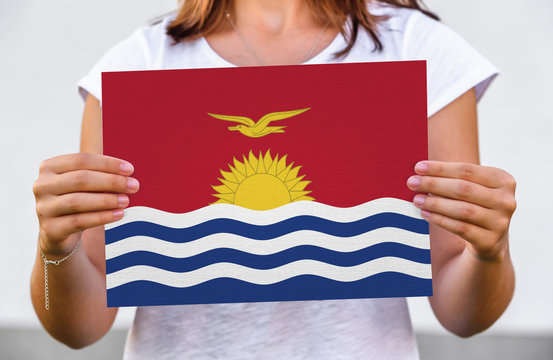 Woman Holds Flag Of Kiribati On Paper Sheet