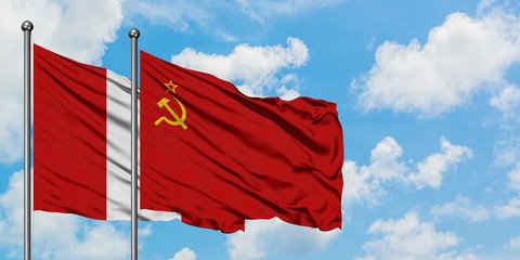 Peru and Soviet Union flag waving in the wind against white cloudy blue sky together. Diplomacy concept, international relations.