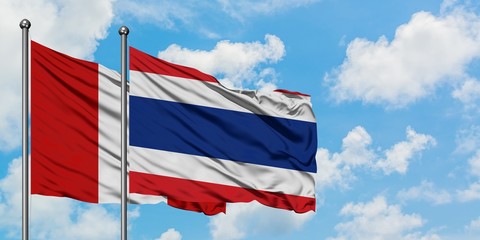 Peru and Thailand flag waving in the wind against white cloudy blue sky together. Diplomacy concept, international relations.