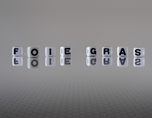 The concept of foie gras represented by black and white letter beads