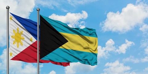 Philippines and Bahamas flag waving in the wind against white cloudy blue sky together. Diplomacy concept, international relations.