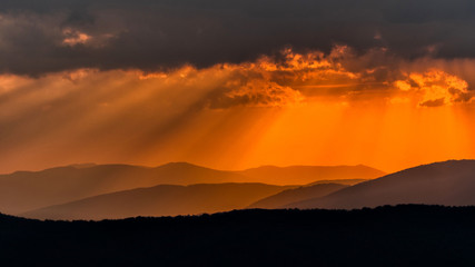 Fototapeta premium Mountains' silhouettes against the orange sky. Beautiful sunset in the Bieszczady Mountains. Poland