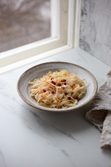 Sauerkraut in rustic plate on marble background with copy space