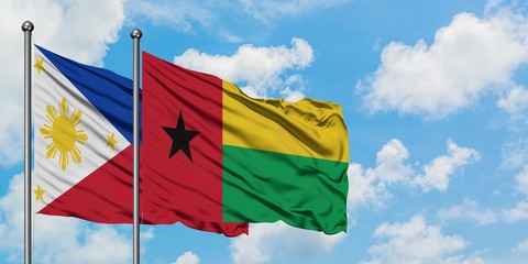 Philippines and Guinea Bissau flag waving in the wind against white cloudy blue sky together. Diplomacy concept, international relations.