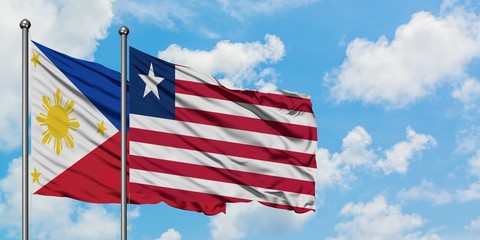 Philippines and Liberia flag waving in the wind against white cloudy blue sky together. Diplomacy concept, international relations.