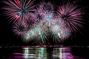 Amazing beautiful colorful fireworks display on celebration night, showing on the sea beach with...